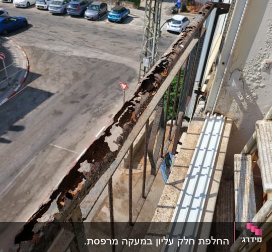 מעקה מתכת חלוד עם קילופים על מרפסת